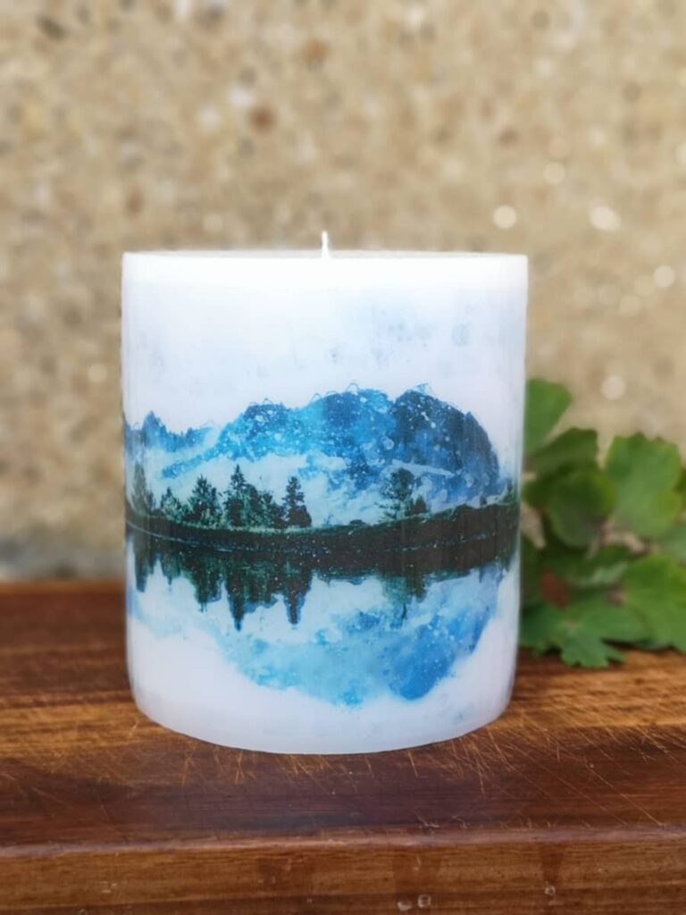 Candle with picture of mountain lake