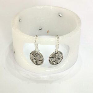 Small lantern with two silver style pendants with tulip flowers.
