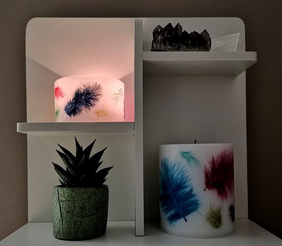 Lighting small lantern on shelf with real coloured feathers