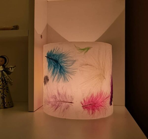 Wax lantern with coloured feathers.