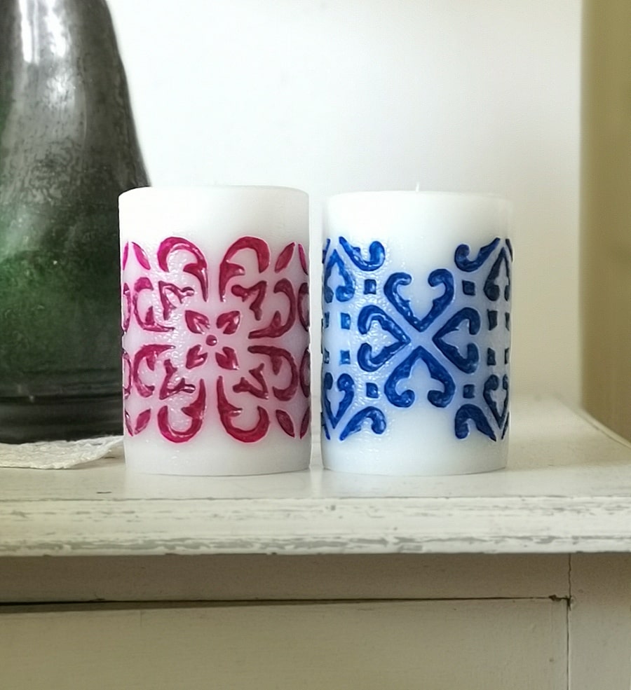 Two medium pillar candles - hand carved and hand painted with purple and blue wax