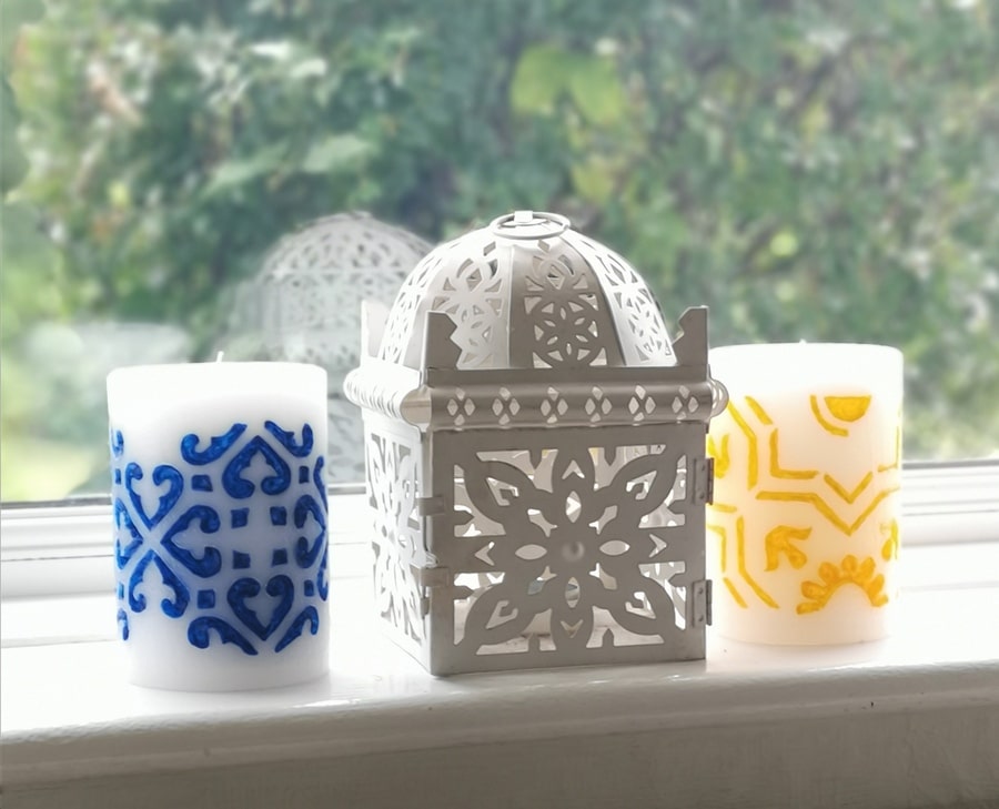 Two medium pillar candles - hand carved and hand painted with blue and yellow wax