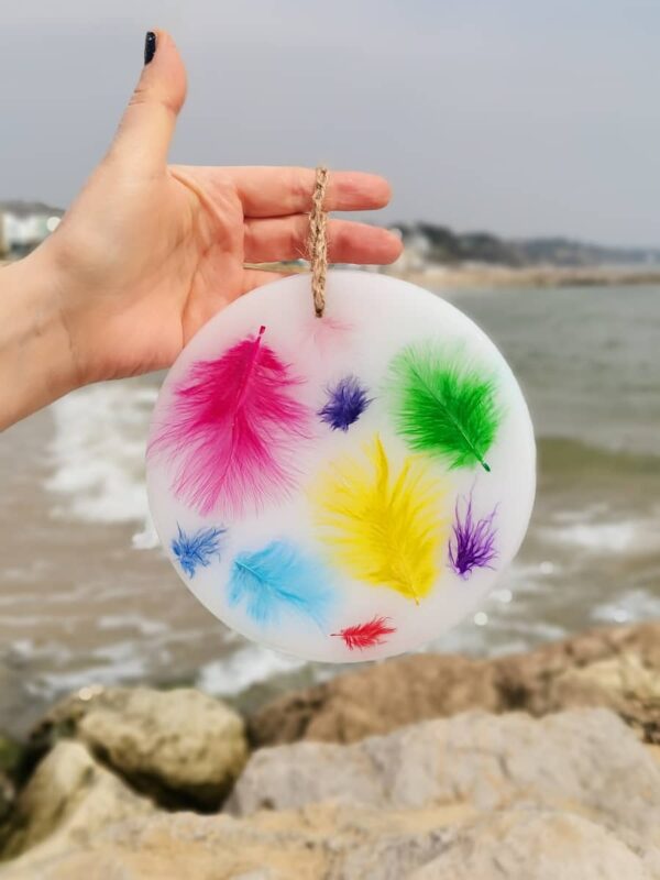 Wax ornament with coloured feathers