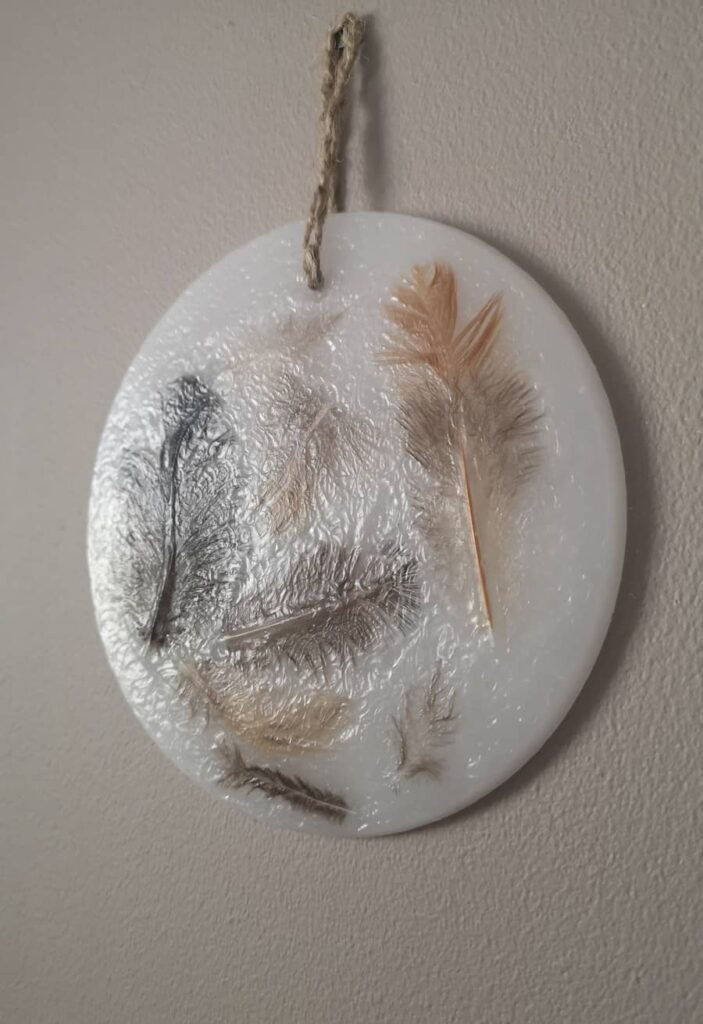 Round wax wall decoration with real natural feathers