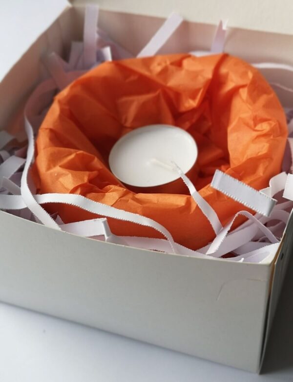 A small wax lantern in a white branded box.