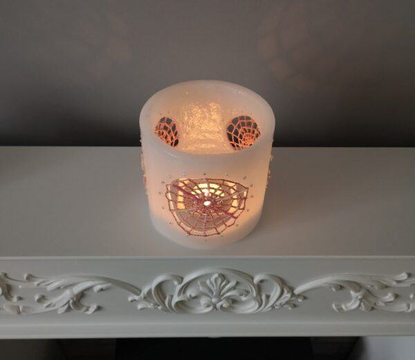 Wax lantern with pink crochet doilies, decorated with tiny beads.