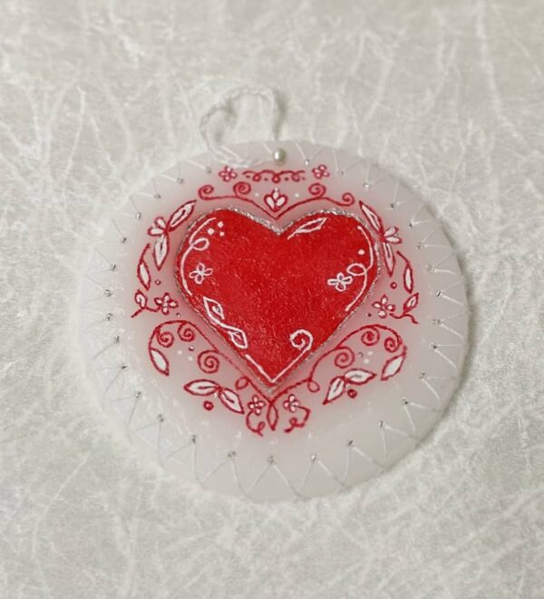 Wax ornament with a felt heart and swirls.
