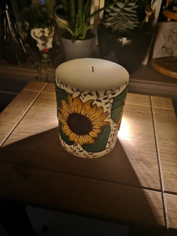 Large pillar candle with felt sunflowers.