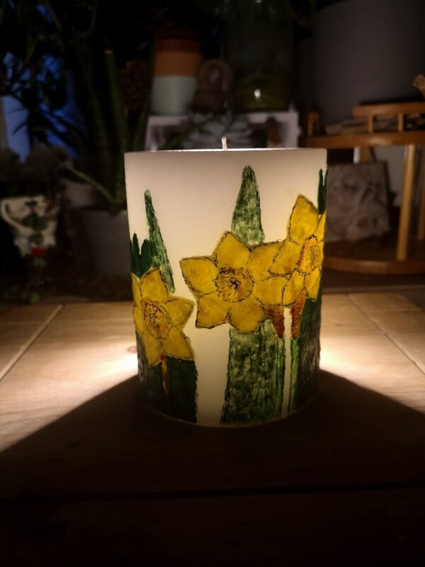 Large pillar candle with felt daffodils.