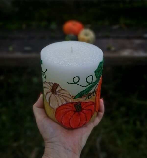 Large pillar candle with felt pumpkins.