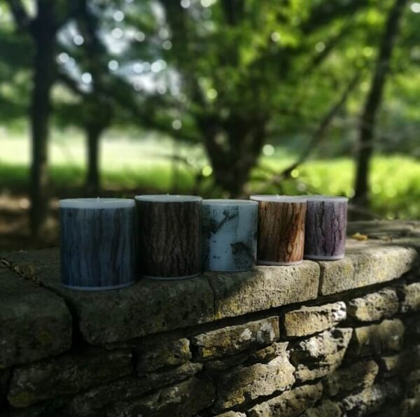 Five large pillar candles with printed different bark tree patterns.