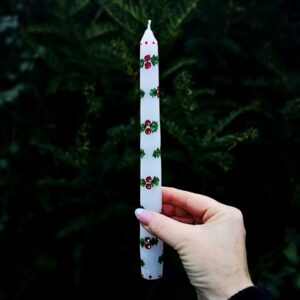 Festive taper candle with Holly pattern.