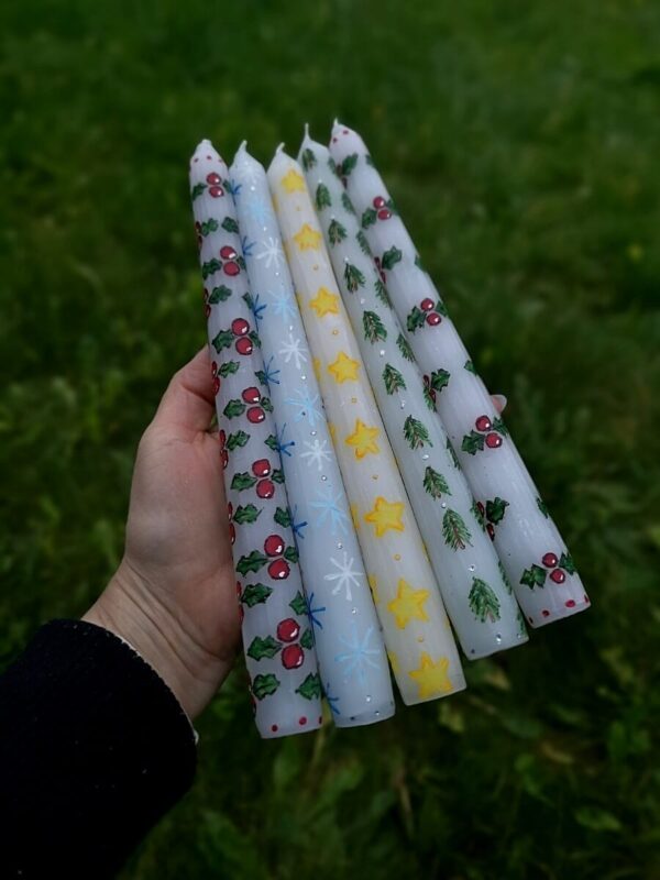 All festive taper candles with stars, holly, snowflakes and Christmas trees.